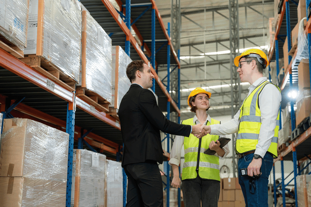 Packaging manufactures shaking hands with distributor in shaking hands in warehouse